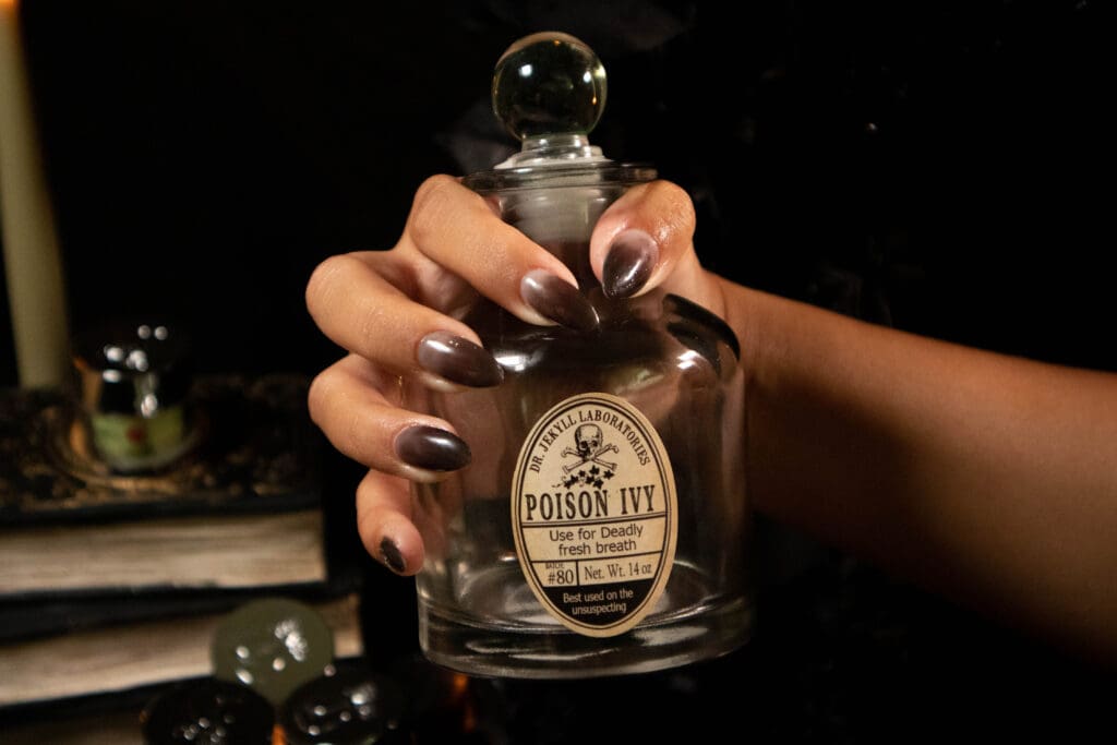 A female model with dip powder nails that change from clear to black in a halloween photo set.